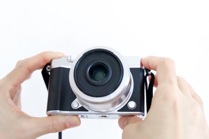 デジカメを両手で持ち、状態を確認する様子