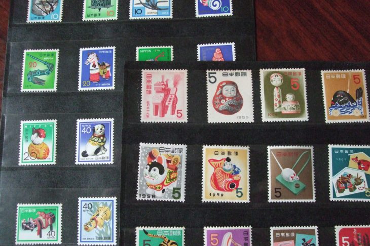 黒いファイルに収納された切手が木製の台の上に置かれている写真