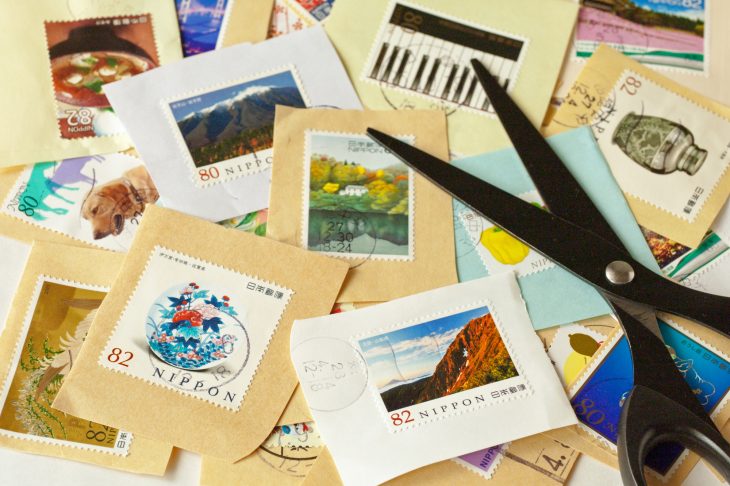 たくさんの使用済み切手の上に置かれたはさみ