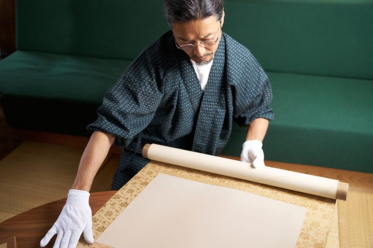 掛け軸を査定する和服姿の男性