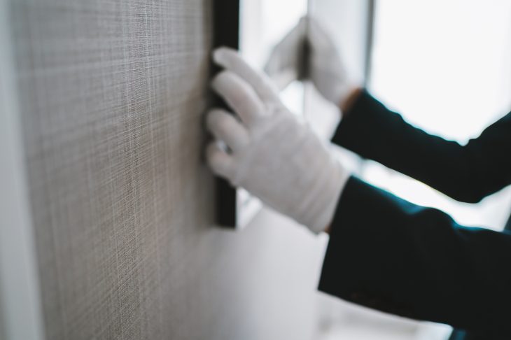 壁に絵画を掛けている人