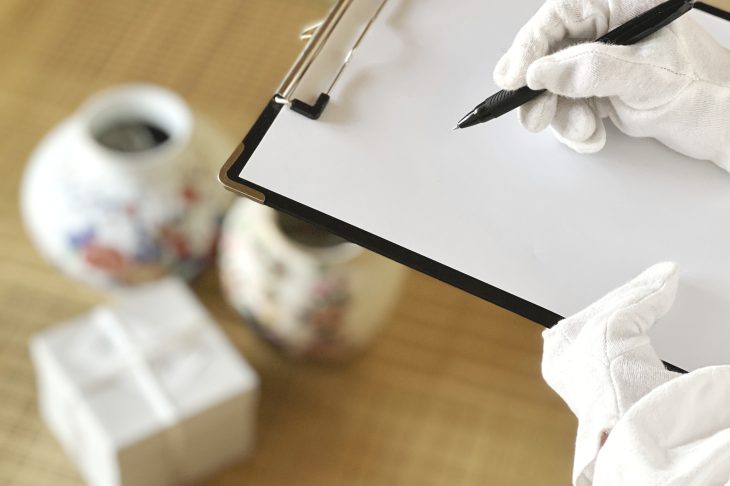 骨董品を査定している人の手元