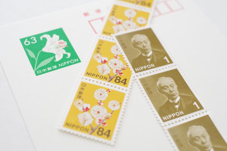 郵便はがきの上に切手が数枚乗っている写真