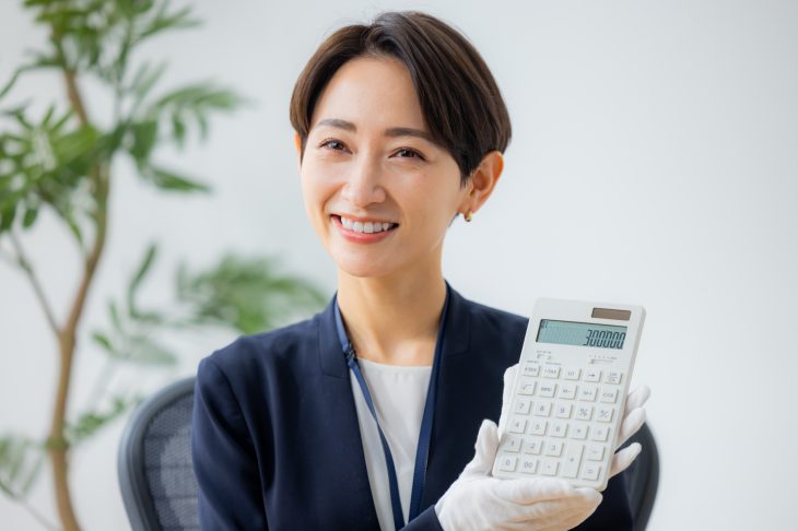電卓で金額を提示する女性査定員