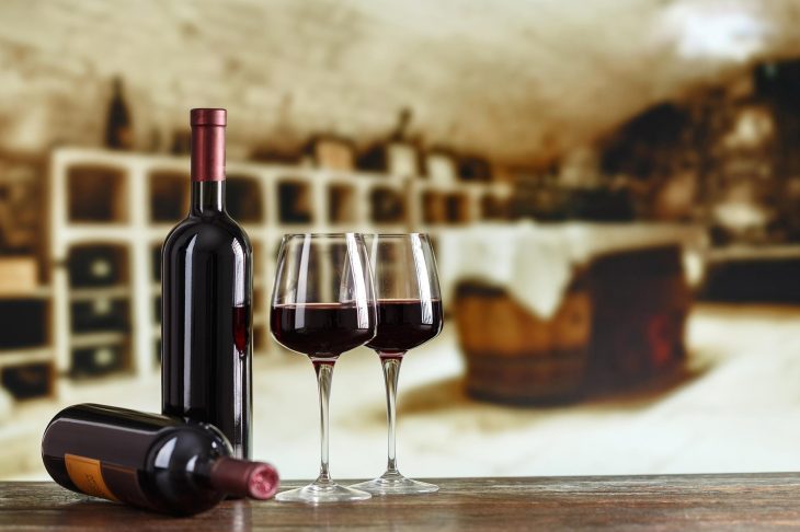 グラスに注がれたワインと2本のワインボトル