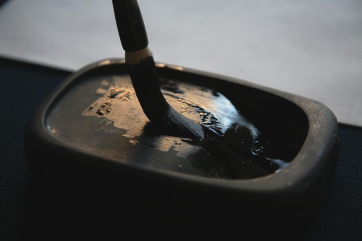 硯の墨を筆に含ませる