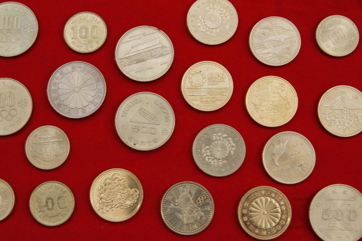 赤いシートの上に並ぶたくさんの記念硬貨