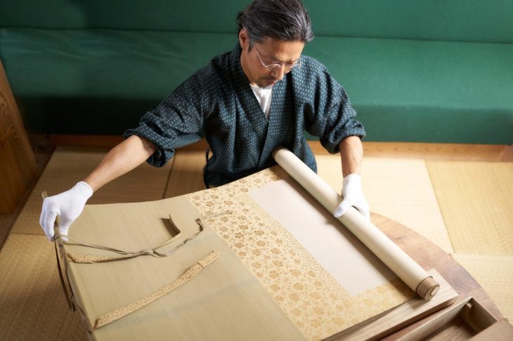 掛け軸を査定する人物