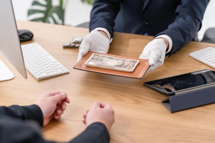 トレーに乗せられた現金の受け渡し