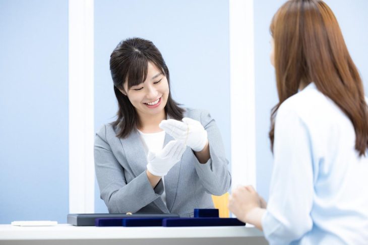 笑顔で手袋を付けて査定をする女性