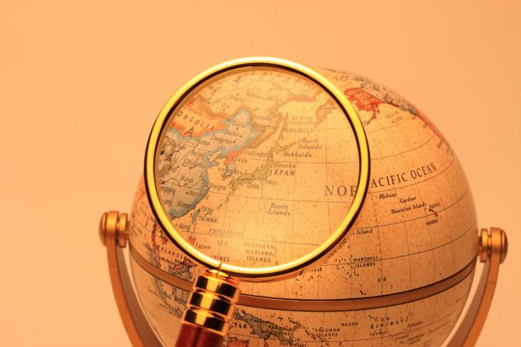 地球儀を虫眼鏡で拡大して見ている様子