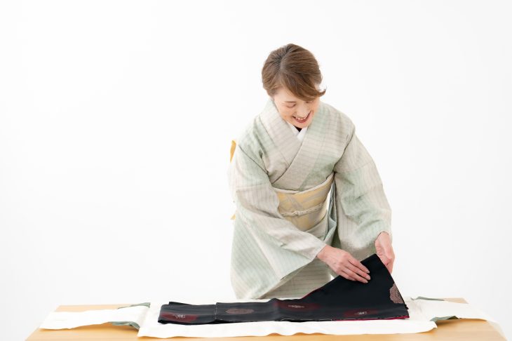 着物を畳む和装の女性