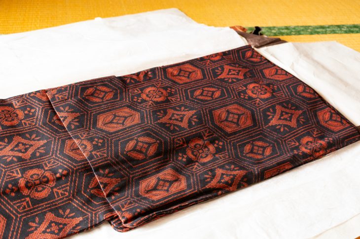 畳の上に畳んで置かれた赤い着物