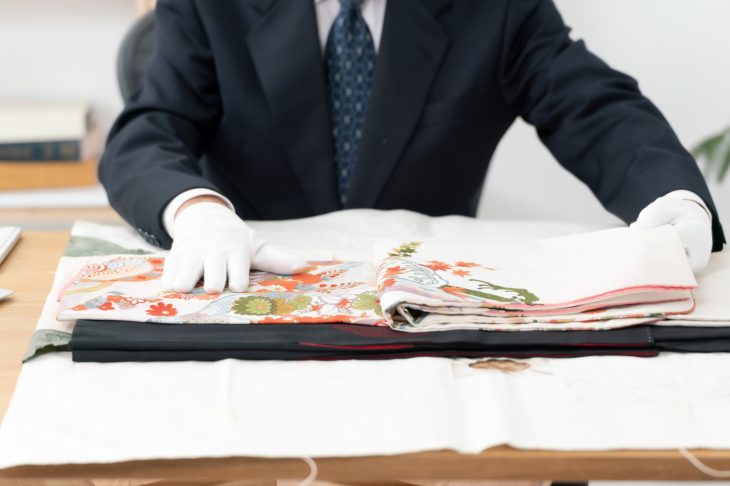着物を丁寧に査定している途中の査定士