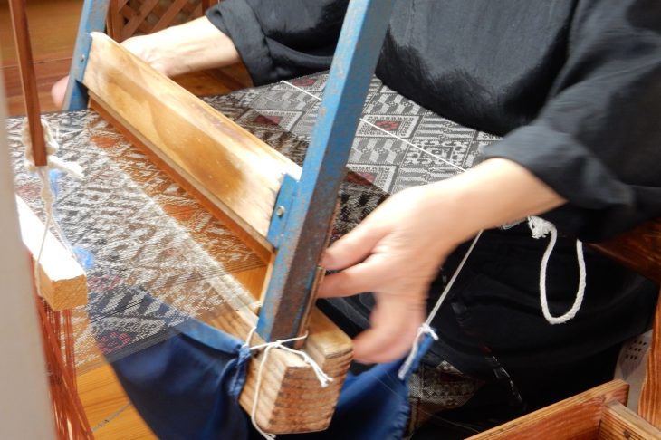 紬のような反物を織っている人
