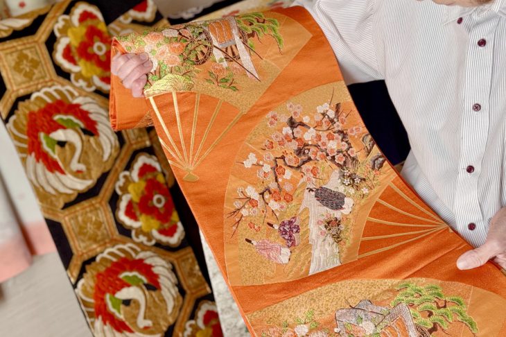平安貴族柄の帯を広げる手元
