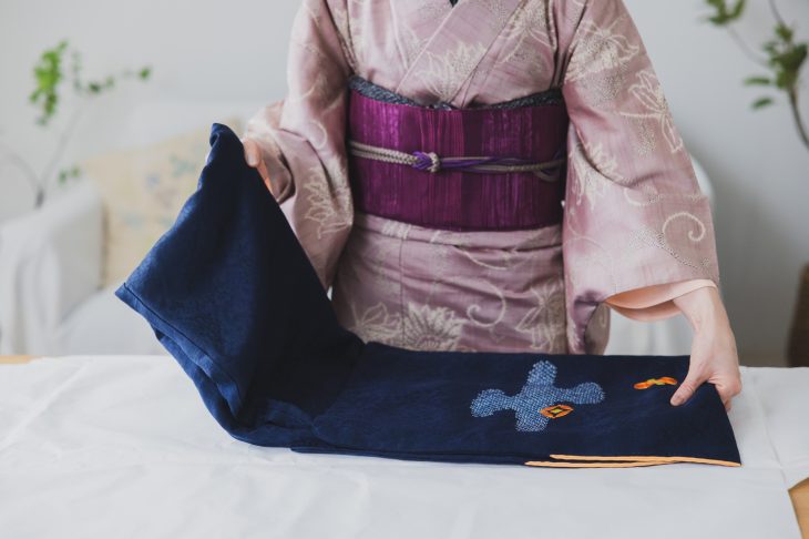 着物を畳んでいる和服姿の女性