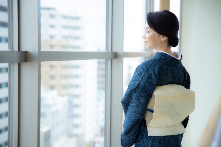 窓辺にたたずむ和装の女性