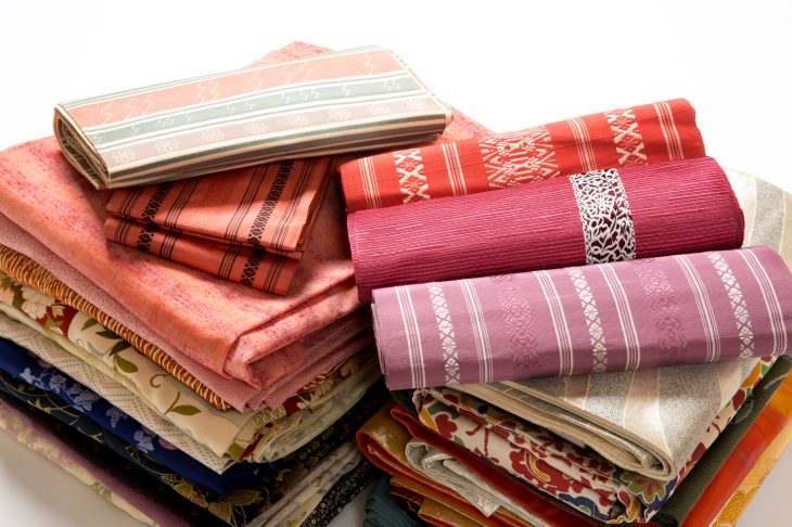 さまざまな柄の反物が積み上げられている写真
