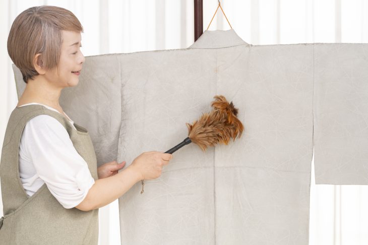 着物の汚れを払っている女性