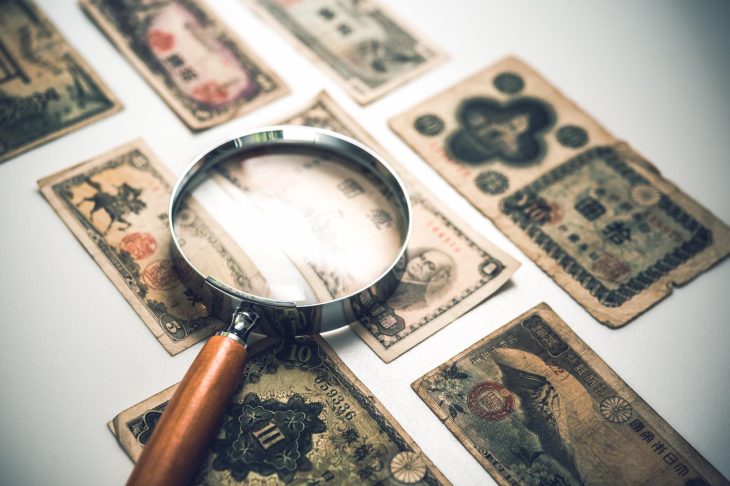 7枚の古い紙幣と虫眼鏡
