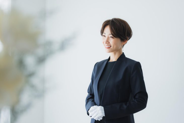 白い手袋をした査定士風の女性