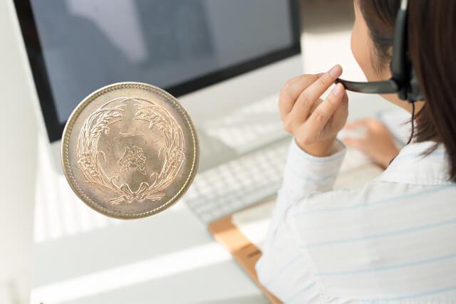 一銭硬貨と、コールセンターで働く女性