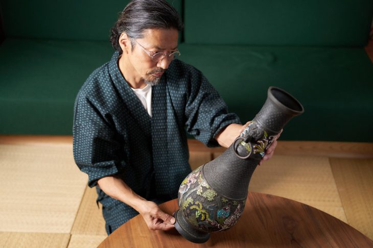 壺を手に取って状態を確認している人