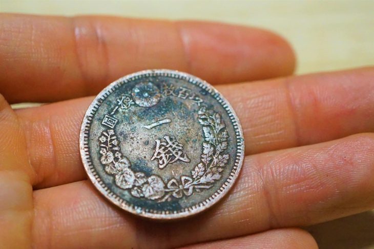 手のひらに一銭硬貨を乗せている写真