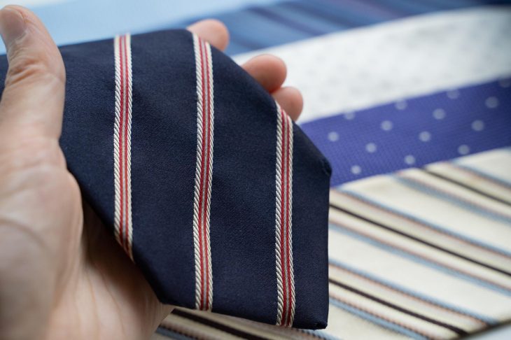 ネイビーのネクタイを手に取る様子