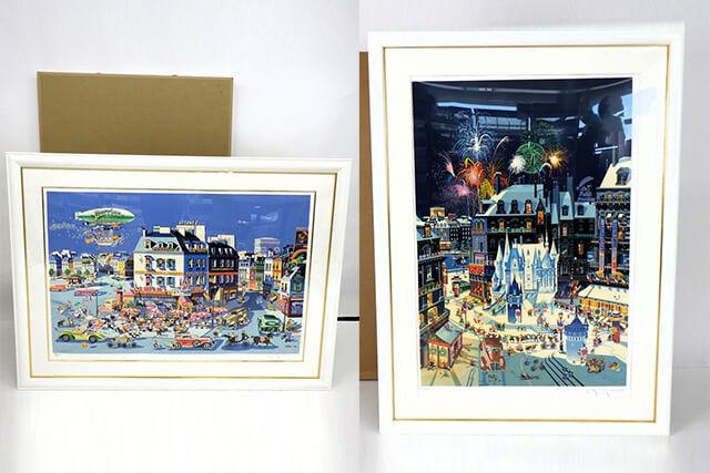 白い額に入ったカラフルな都市風景の版画作品が2点並べて展示されている様子