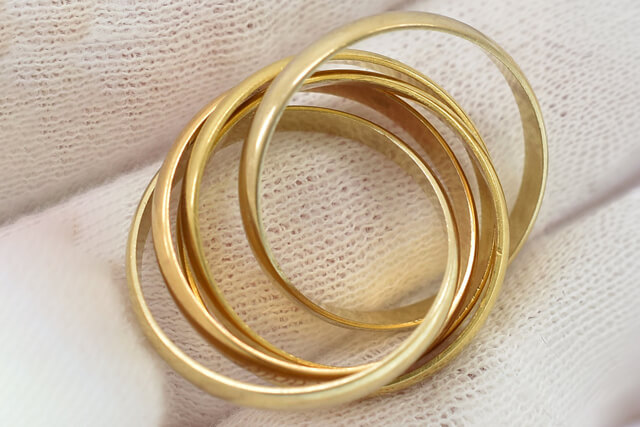 買取福ちゃんの査定士がトリニティリングの刻印や状態などを確認する様子