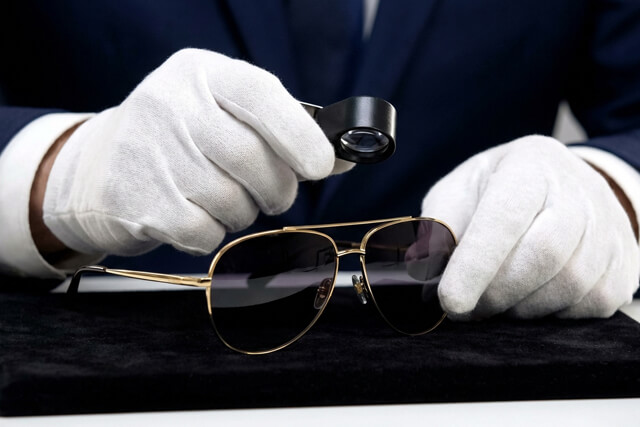 プロの査定士がサングラスのフレームやレンズの状態を確認している様子