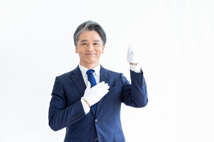 白手袋をして胸に手を当てる男性