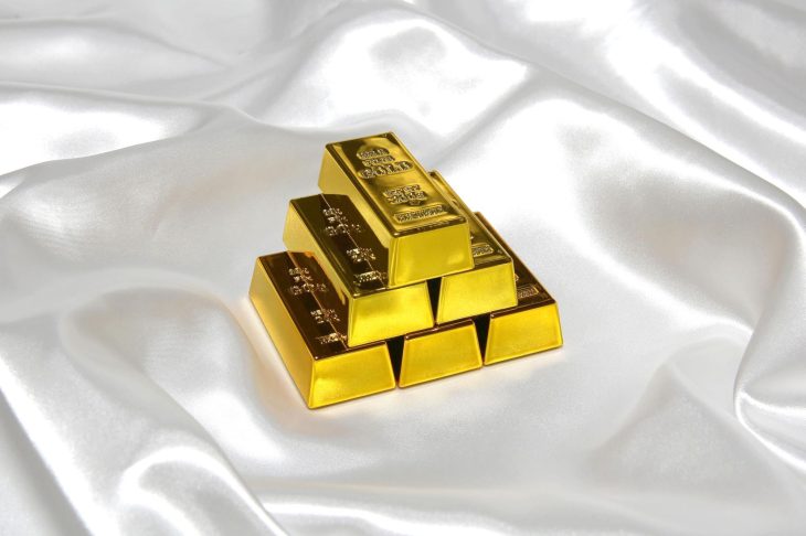 白い布の上に積み重ねられた金の延べ棒