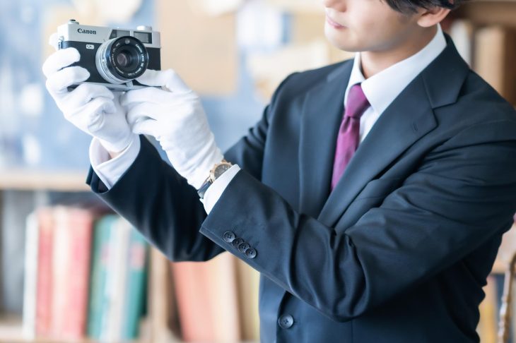 カメラを丁寧にチェックしている査定士