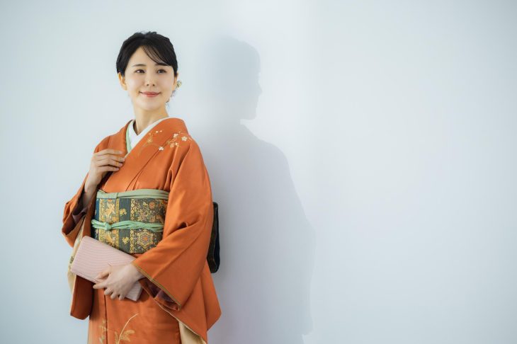 オレンジ色の訪問着を着た女性