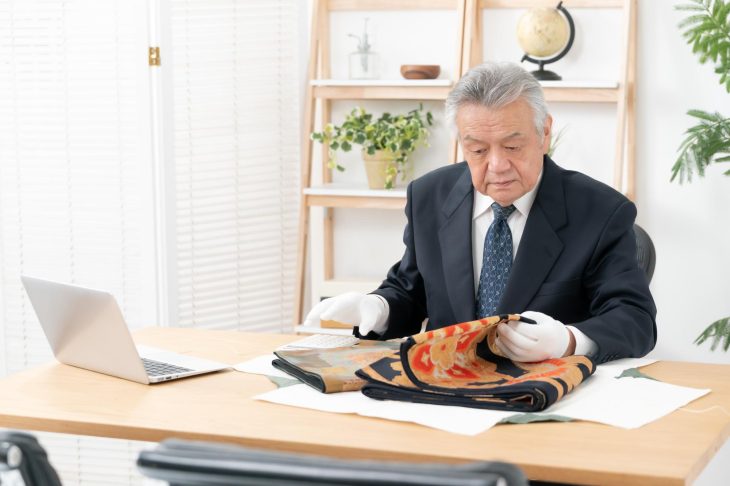 着物を念入りにチェックしている査定士