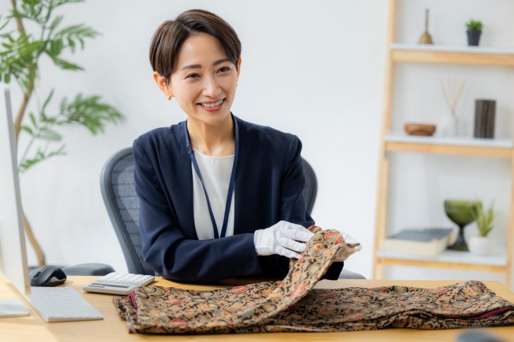 着物を手にとって細かく確認している査定士
