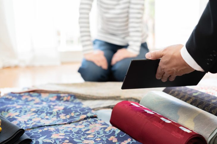着物の訪問査定をし、タブレットを提示する様子