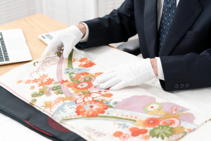 着物を丁寧に査定している査定士
