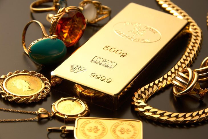 金の延べ棒と指輪やネックレスなどのジュエリーが並べられている