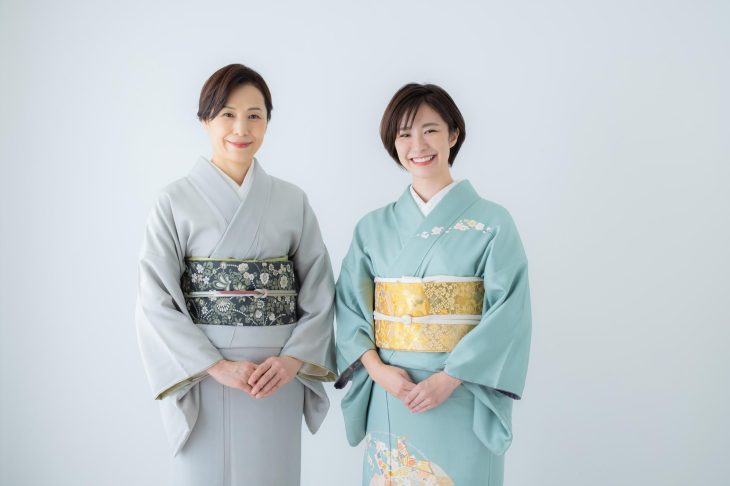 色無地を着た女性と訪問着を着た女性