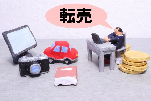 「転売」という吹き出しがついた、パソコンに向かう人物の粘土ミニチュア