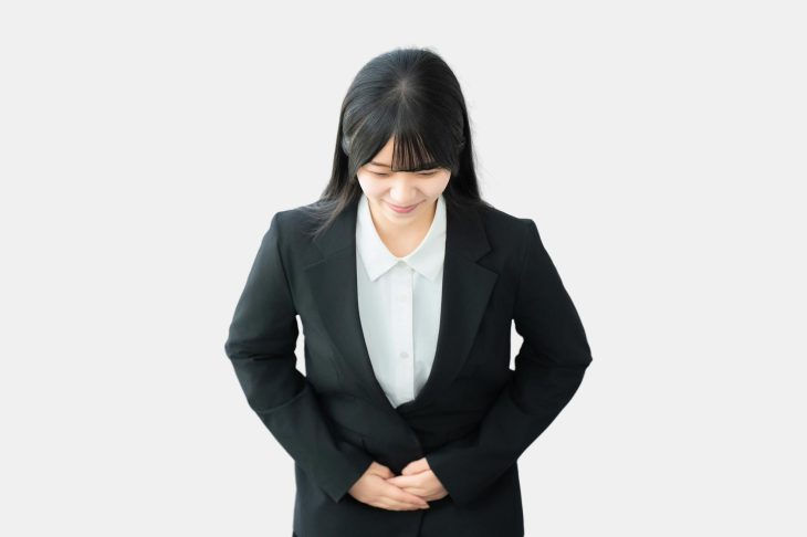 スーツ姿でお辞儀をする女性