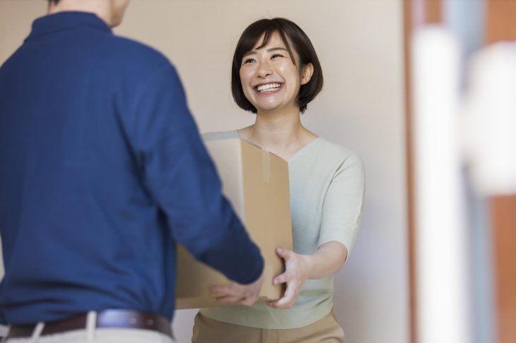 宅配便の荷物を受け取る女性