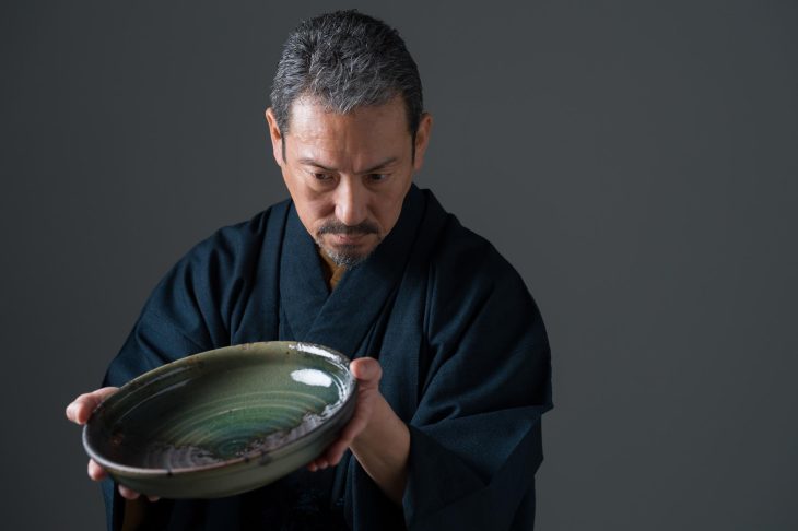 皿を丁寧に確認しているひとりの男性