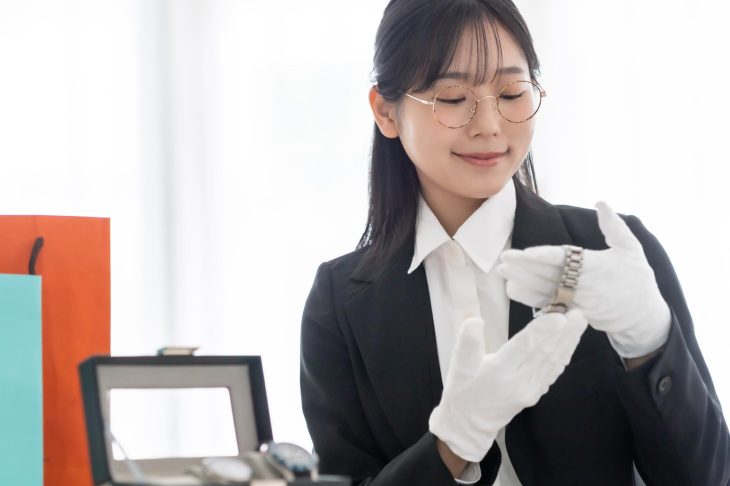 時計を念入りに確認している査定士