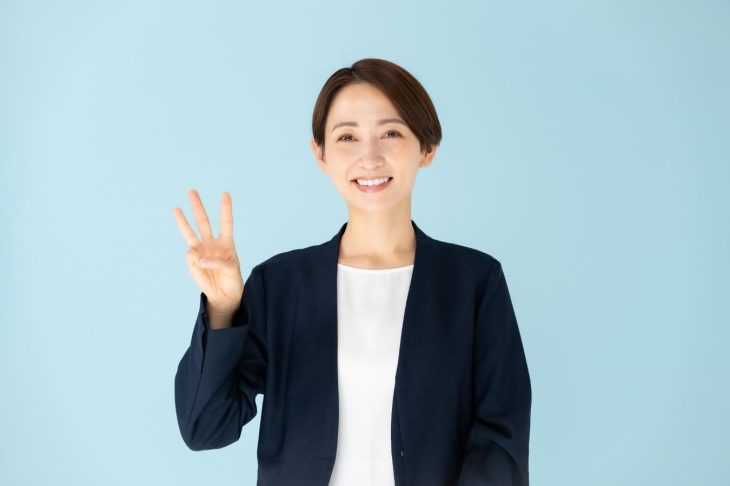 3本の指を立てている女性