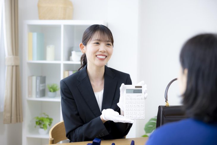 電卓で金額を提示する女性査定士